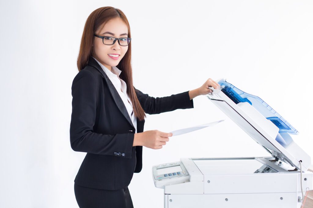 sorrindo mulher de negocio asiatica que usa a maquina copiadora